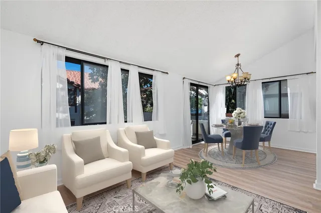 a living room with furniture two window and a chandelier