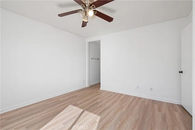 a view of a livingroom with wooden floor and a ceiling fan