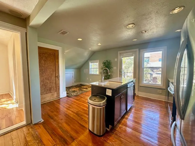 a kitchen with stainless steel appliances granite countertop a stove and a wooden floors