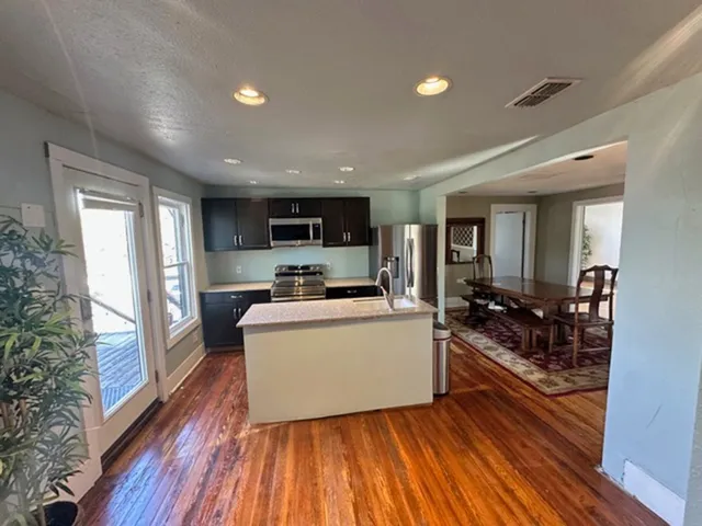 a living room with furniture and a wooden floor
