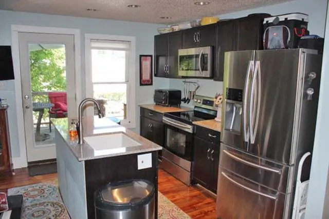 a kitchen with stainless steel appliances a stove a refrigerator and a sink