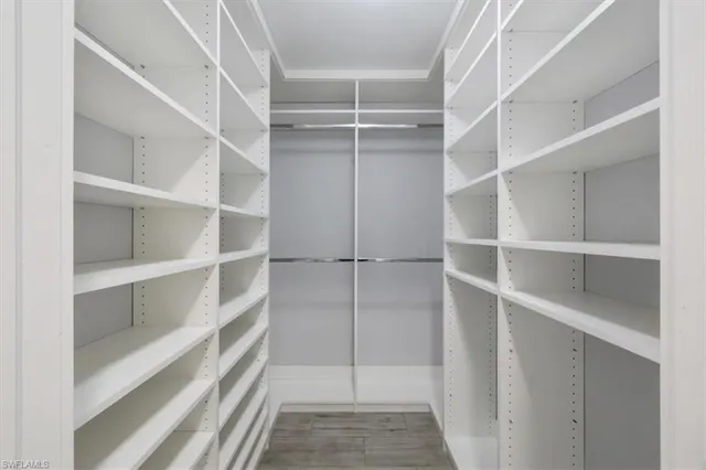 a view of walk in closet with empty racks