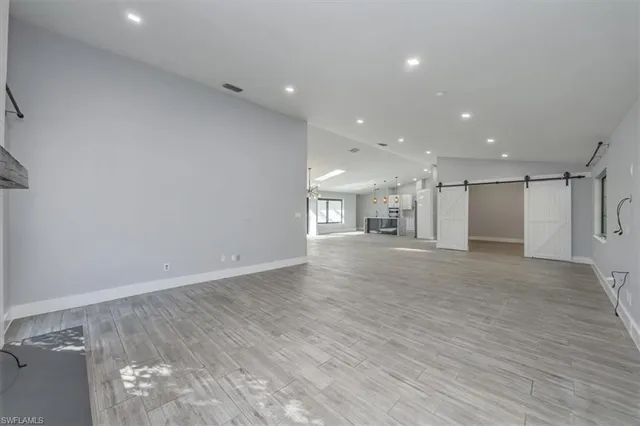 a view of a big room with wooden floor and a window