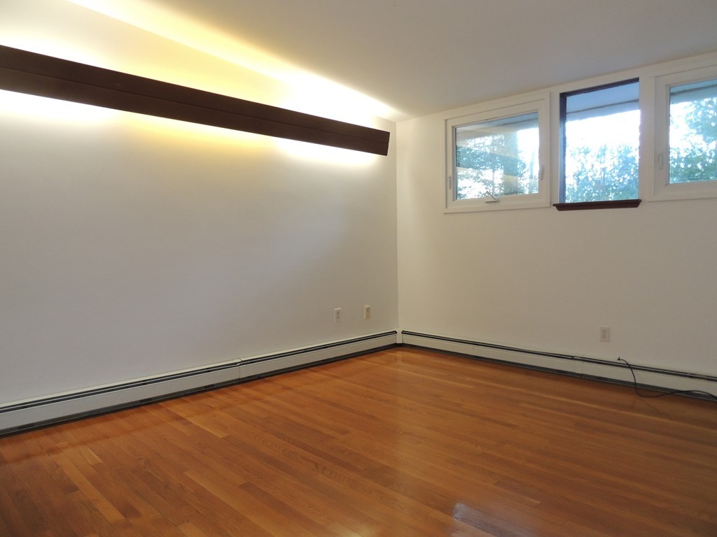 25 Algonquin Road Canton, MA 02021 - Photo 6 of 9 a view of an empty room with wooden floor and a window