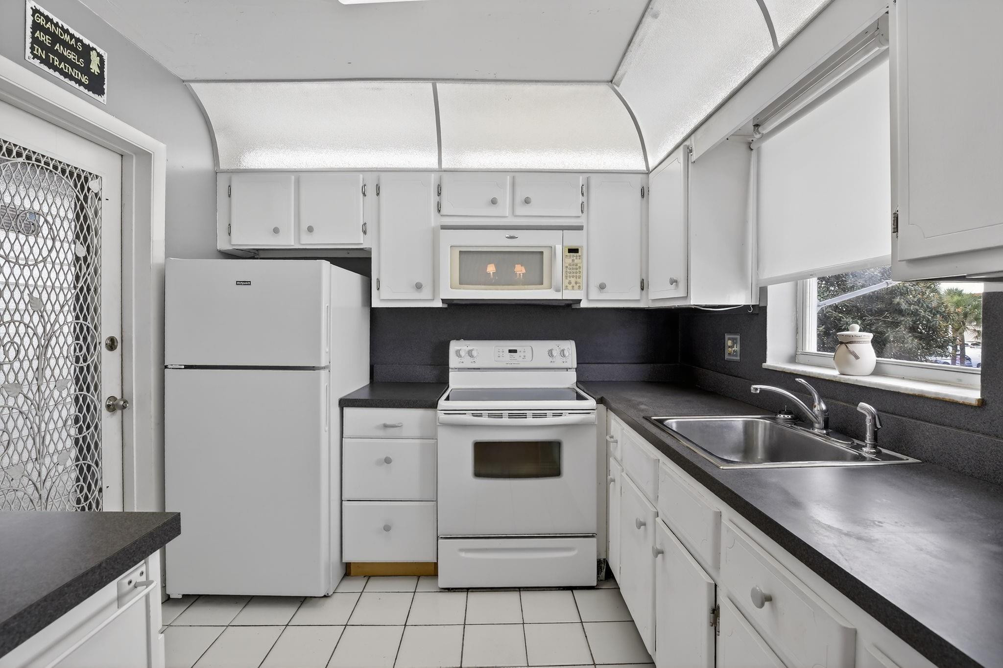 5300 Washington Street, Unit I201 Hollywood, FL 33021 - Photo 8 of 35 a kitchen with white cabinets and white appliances