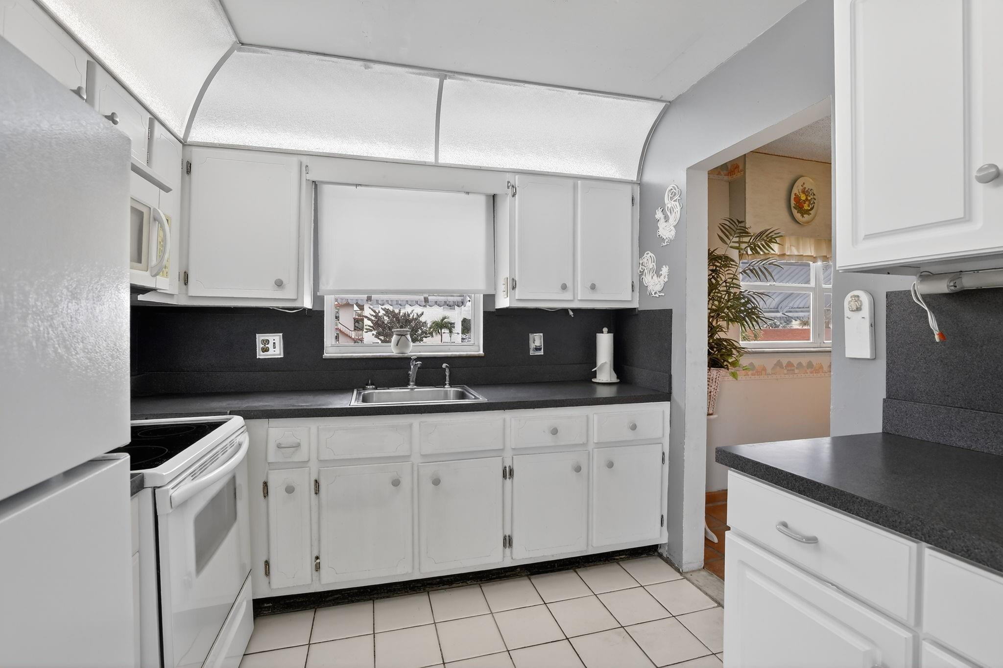 5300 Washington Street, Unit I201 Hollywood, FL 33021 - Photo 10 of 35 a kitchen with granite countertop a sink a stove and cabinets