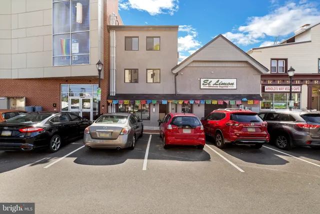 a front view of a building with cars parked