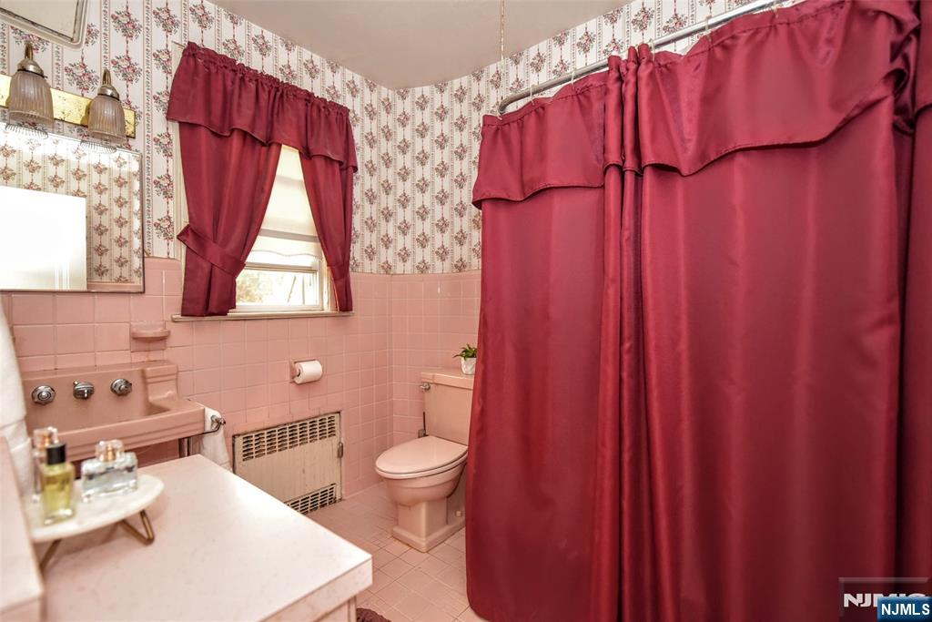 255 Pearsall Avenue Ridgewood, NJ 07450 - Photo 27 of 39 a bathroom with a sink a toilet and shower curtain