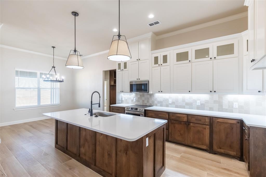a kitchen with kitchen island a sink a counter space appliances and a window