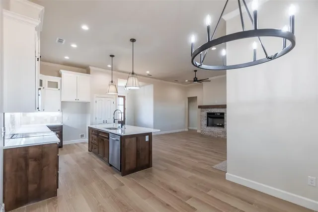 a kitchen with stainless steel appliances granite countertop a sink a stove and a wooden floors