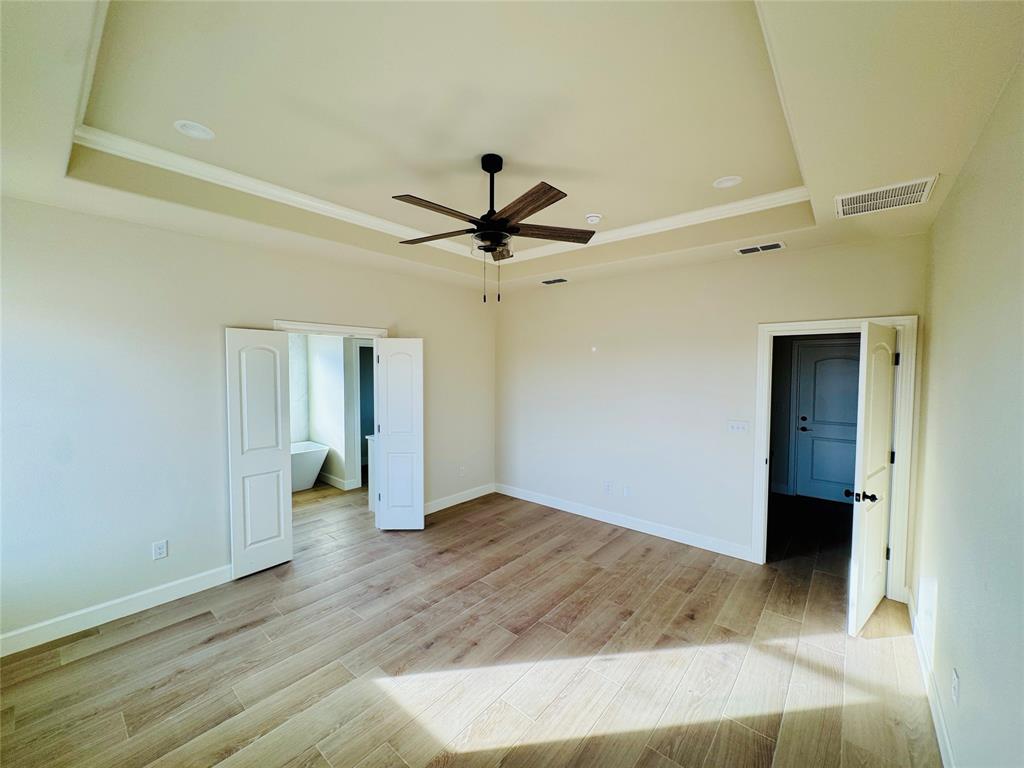 245 Indian Ridge Road Tuscola, TX 79562 - Photo 12 of 21 Unfurnished bedroom with a raised ceiling, wood finish floors, ceiling fan, and crown molding