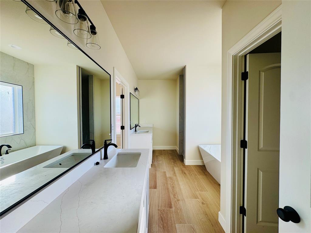 245 Indian Ridge Road Tuscola, TX 79562 - Photo 14 of 21 Bathroom featuring a freestanding bath, vanity, and light wood finished floors