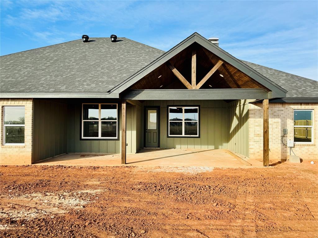 245 Indian Ridge Road Tuscola, TX 79562 - Photo 16 of 21 Back of property featuring a patio area, roof with shingles, brick siding, and board and batten siding
