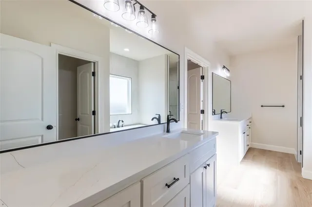 a bathroom with a double vanity sink and mirror with shower