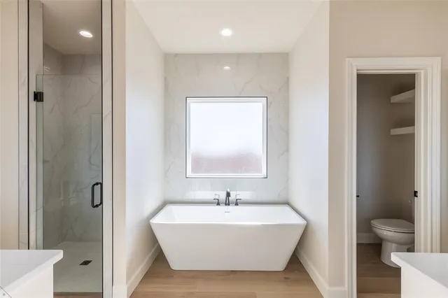 a bathroom with a white tub shower and sink