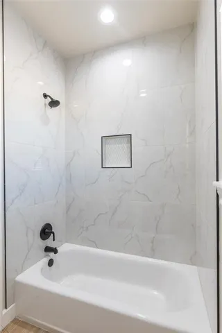 an empty room with wooden floor ceiling fan and windows