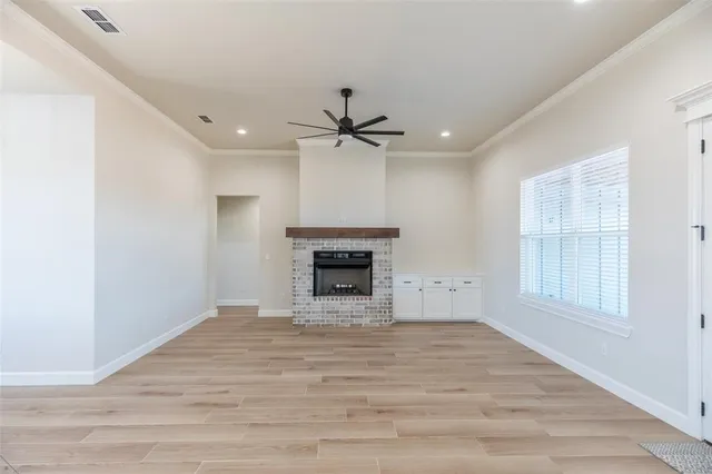 an empty room with windows and a fireplace