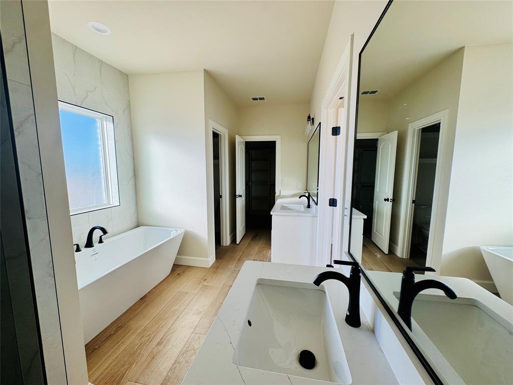 245 Indian Ridge Road Tuscola, TX 79562 - Photo 6 of 21 Full bath featuring a soaking tub, vanity, and light wood-style flooring