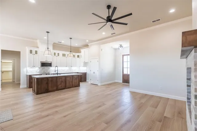 a large white kitchen with a large window a sink and stainless steel appliances