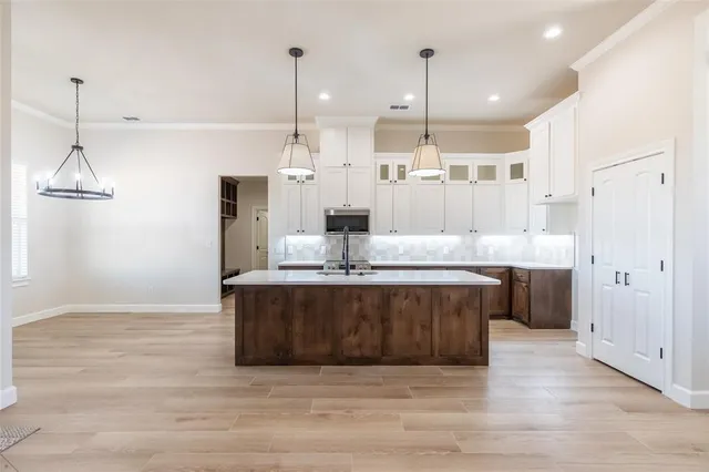 a kitchen with kitchen island a sink and a stove top oven