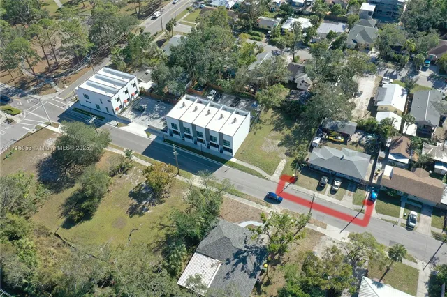 an aerial view of residential house with outdoor space and trees all around