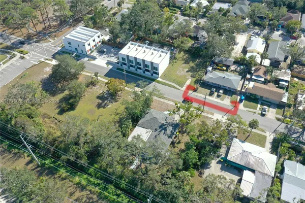 an aerial view of residential house with outdoor space and trees all around