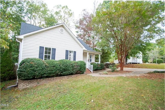 a view of a house with a yard and potted plants