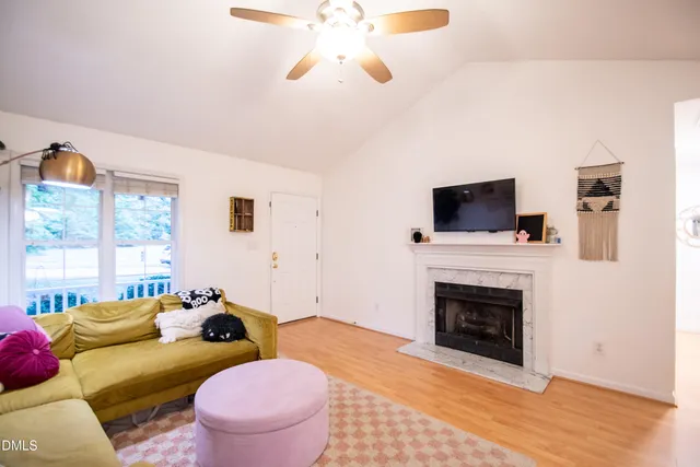 a living room with furniture a flat screen tv and a fireplace