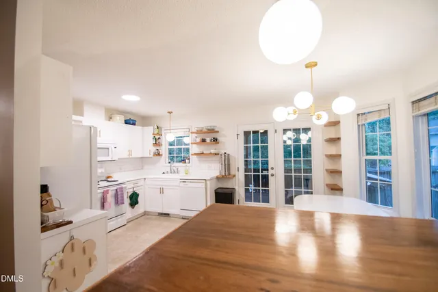 a large kitchen with kitchen island a large counter space a sink appliances and cabinets