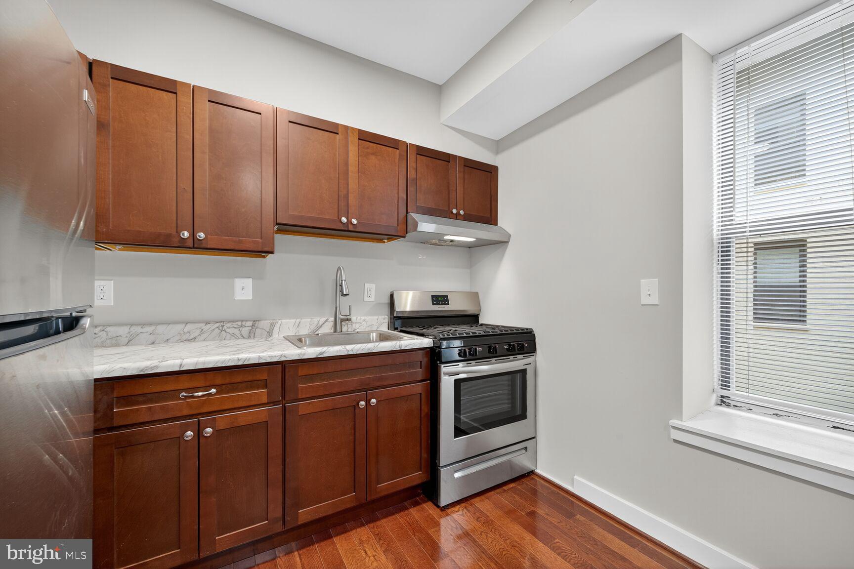 1440 W Street Northwest, Unit 106 Washington, DC 20009 - Photo 9 of 25 a kitchen with stainless steel appliances granite countertop a stove a sink and a microwave