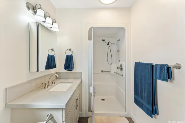 a bathroom with a sink vanity granite shower and a mirror