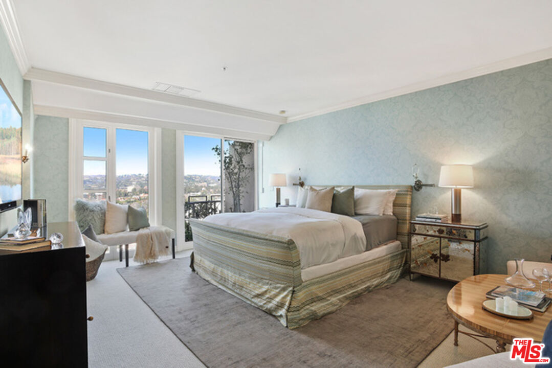 10580 Wilshire Boulevard, Unit 19NW Los Angeles, CA 90024 - Photo 13 of 20 a spacious bedroom with a bed a table and chairs