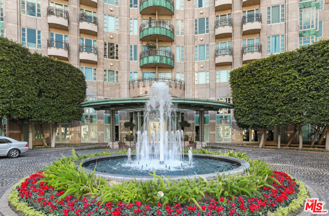 10580 Wilshire Boulevard, Unit 19NW Los Angeles, CA 90024 - Photo 18 of 20 a front view of a building with a garden and flowers