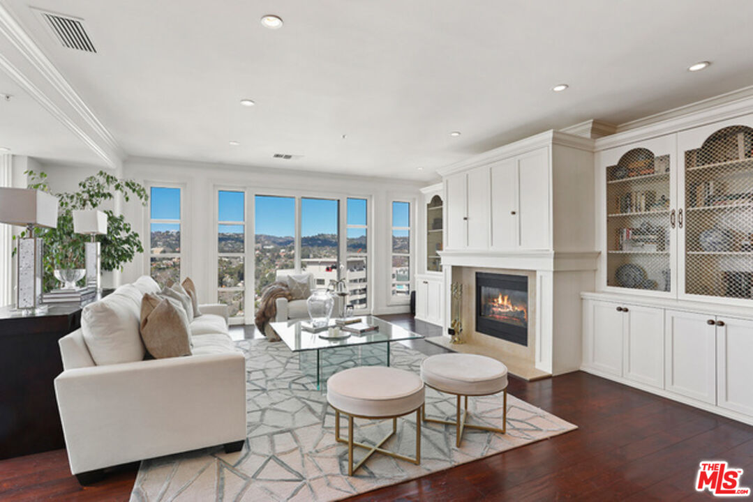 10580 Wilshire Boulevard, Unit 19NW Los Angeles, CA 90024 - Photo 2 of 20 a living room with furniture a fireplace and a table
