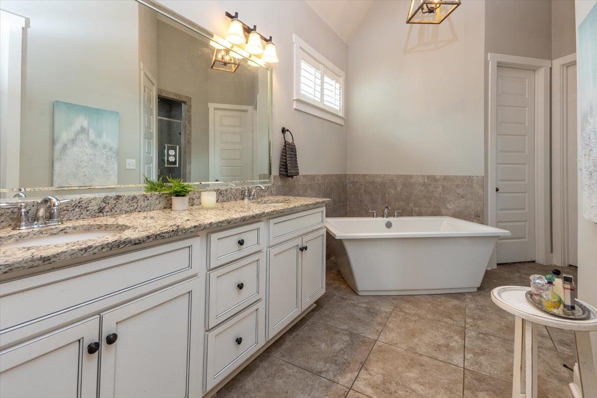 608 Cypress Run Cove Collierville, TN 38017 - Photo 19 of 40 Full bath featuring double vanity, a freestanding bath, tile walls, wainscoting, and lofted ceiling