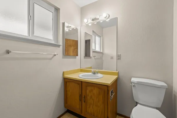 a bathroom with a toilet sink and mirror