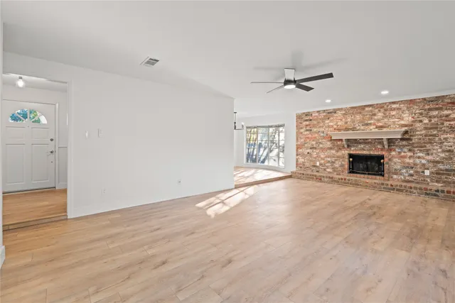 an empty room with windows and fireplace