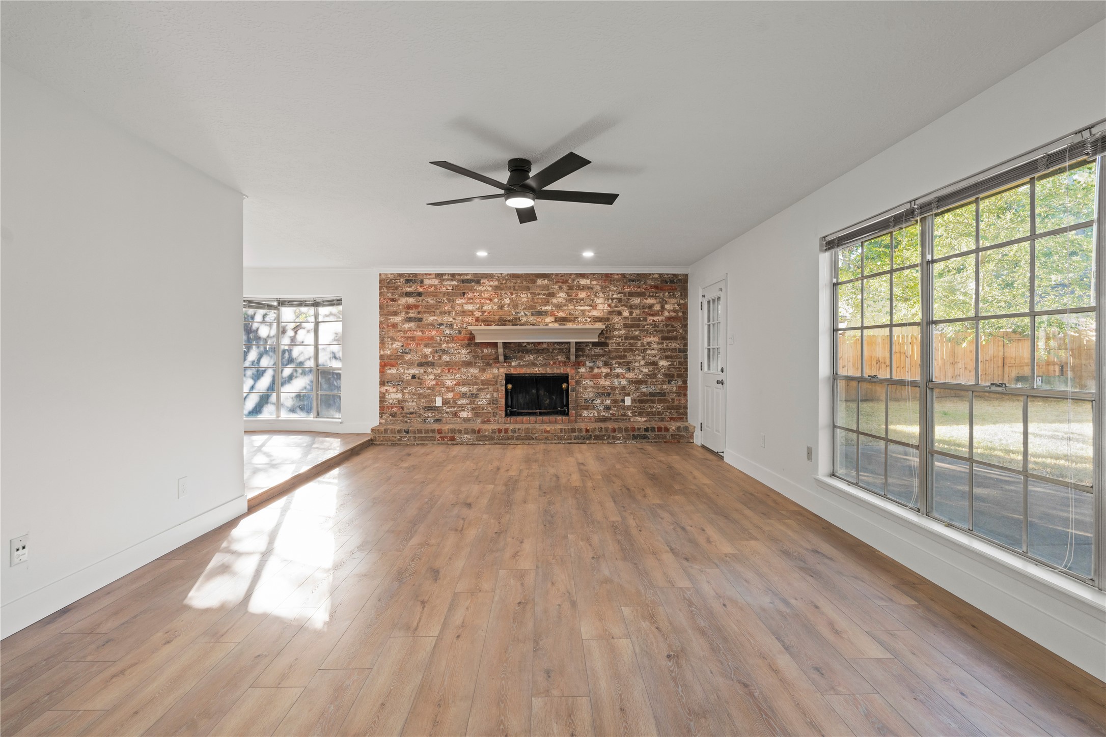 19415 Enchanted Oaks Drive Spring, TX 77388 - Photo 14 of 48 wooden floor fireplace and windows in an empty room