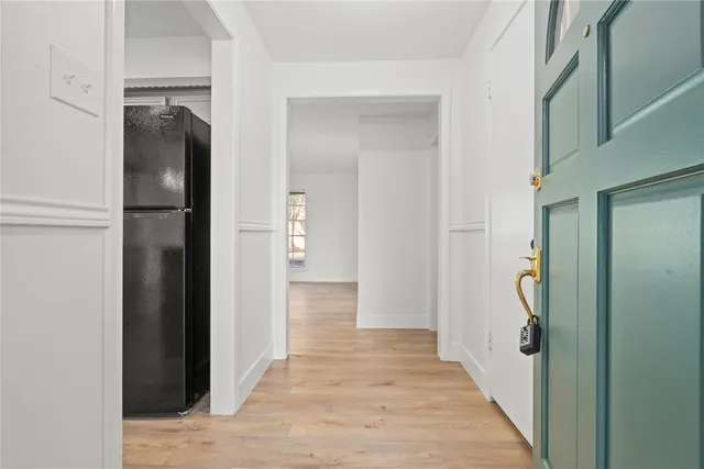 a view of hallway with walk in closet and wooden floor