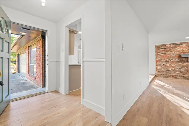 a view of hallway with livingroom and wooden floor