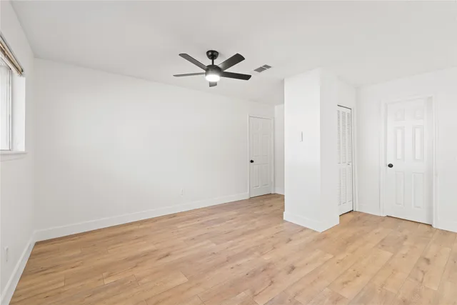 a view of empty room with wooden floor