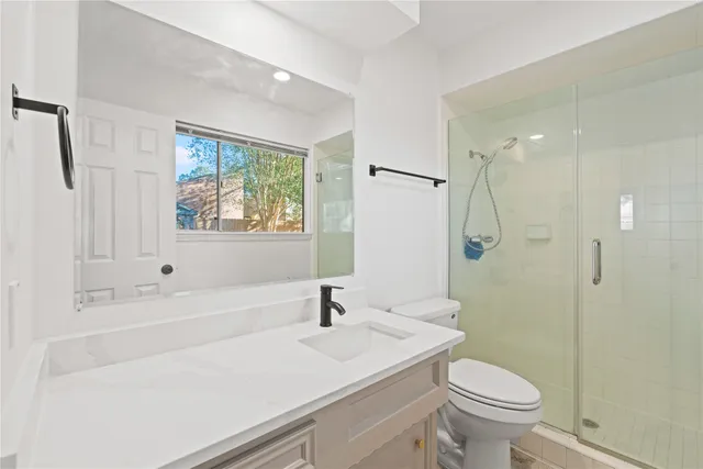 a bathroom with a sink a toilet and shower