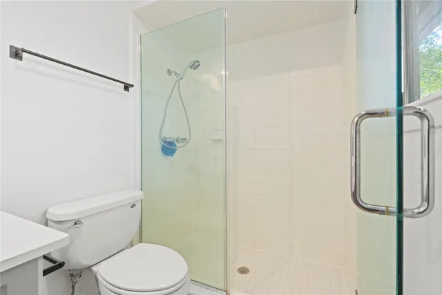 a white toilet sitting next to a shower