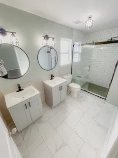 a bathroom with a double vanity sink mirror and toilet
