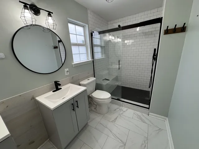 a bathroom with a toilet a sink and mirror