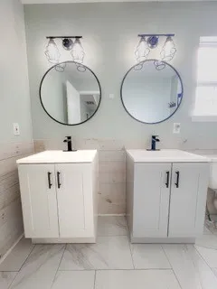 a bathroom with a double vanity sink mirror and vanity