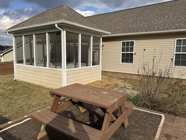 a view of a house with wooden deck and furniture