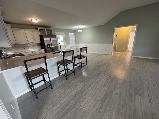 a open kitchen with dining table chairs and wooden floor