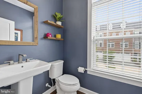 a bathroom with a sink a toilet and a window