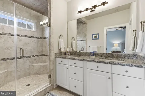 a bathroom with a granite countertop sink mirror and shower